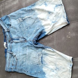 Bleach washed denim shorts with white paint splatter print
